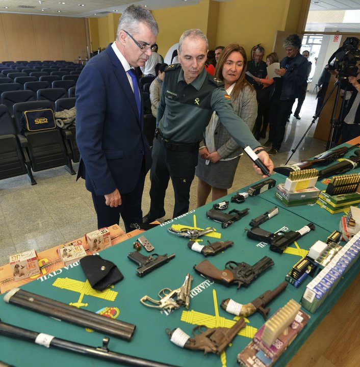 El delegado y la subdelegada del Gobierno, viendo las armas requisadas.