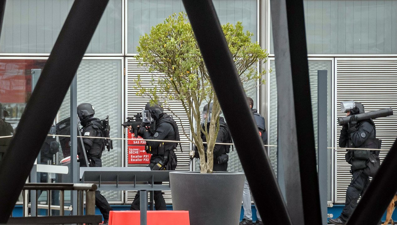 Fuerzas de seguridad se disponen a entrar en las instalaciones del aeropuerto parisino de Orly tras la alerta.
