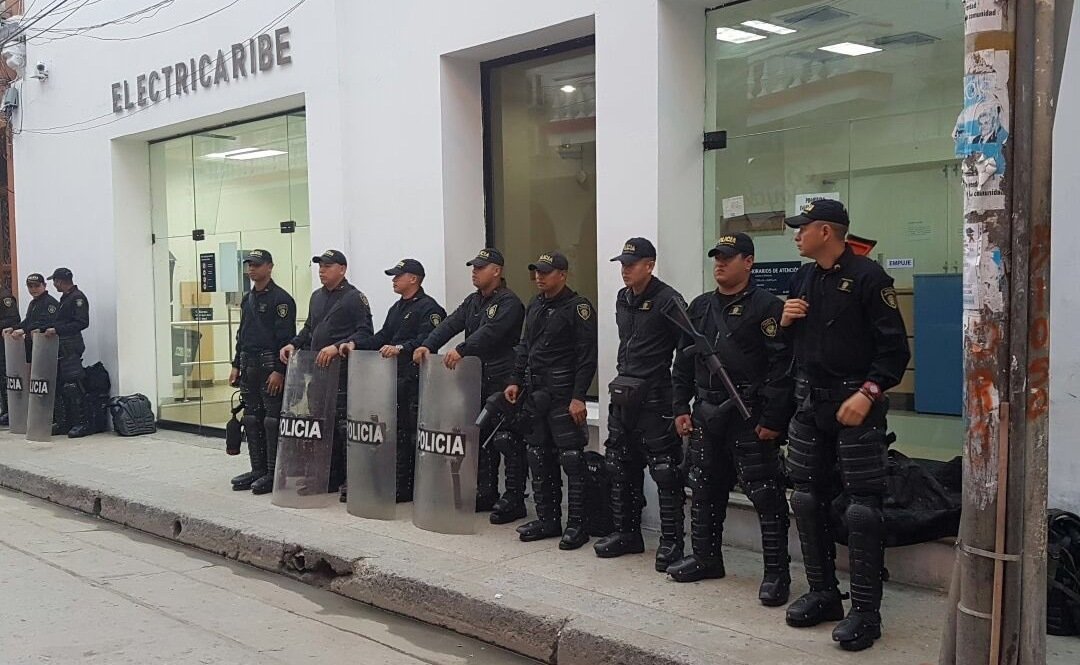 Policías armados de Colombia custodian una sede de Electricaribe.