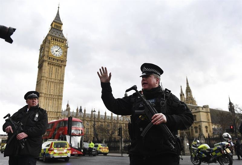 Agentes de policía británicos permanecen en guardia tras un tiroteo ante el Parlamento en Londres.