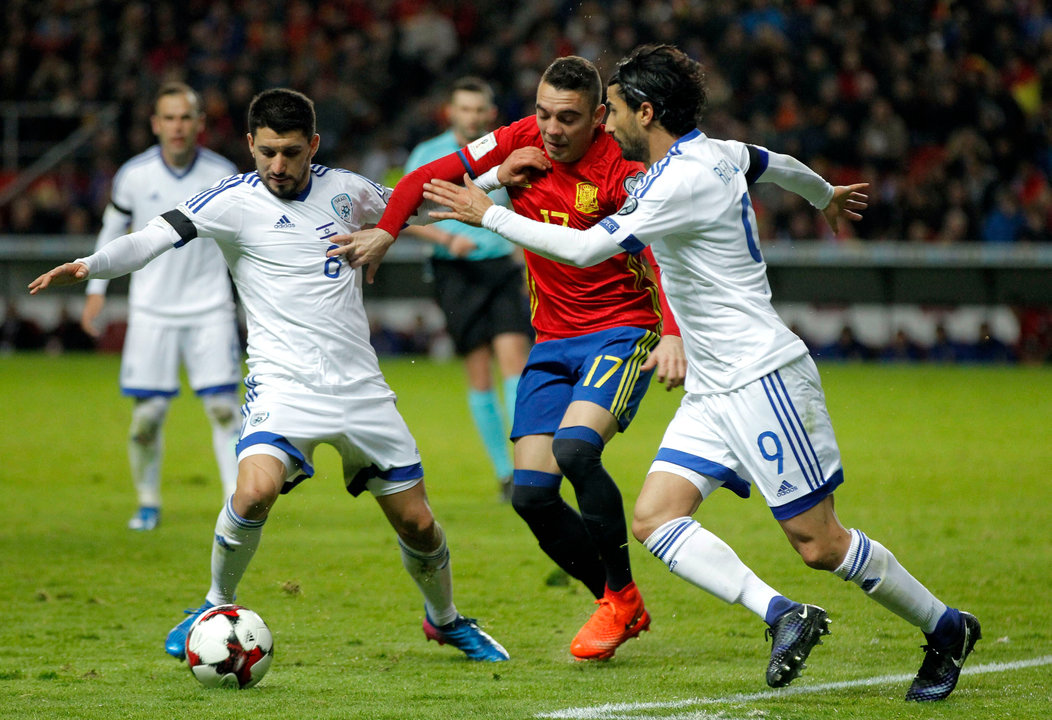 El céltico Iago Aspas disputa un balón con los jugadores de la selección de Israel Natcho (i) y Refaelov durante el partido de ayer en Gijón.