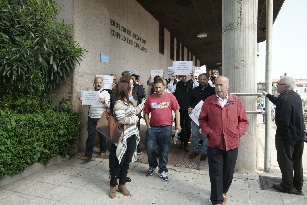 Juan Fernández, en el centro,  ayer a la salida de los juzgados tras el juicio por el desahucio.