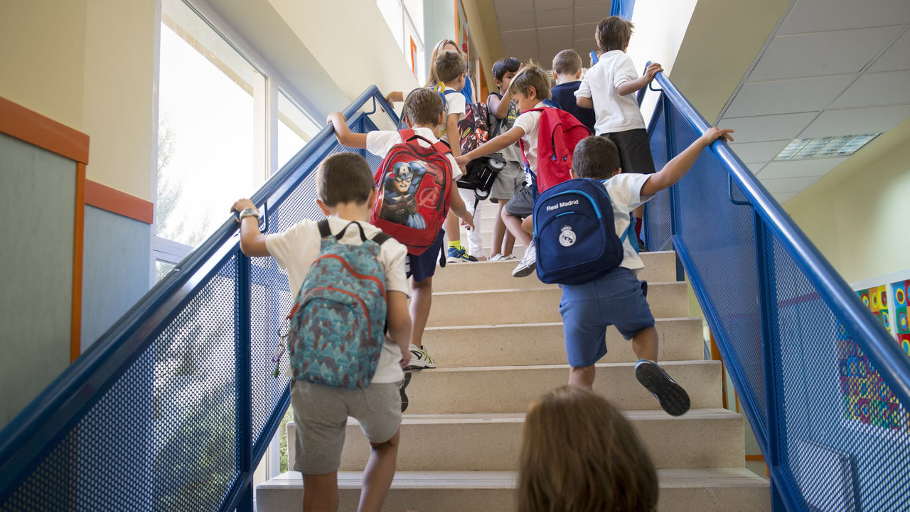 Un grupo de alumnos en las escaleras de acceso a las aulas, en el interior de un colegio.
