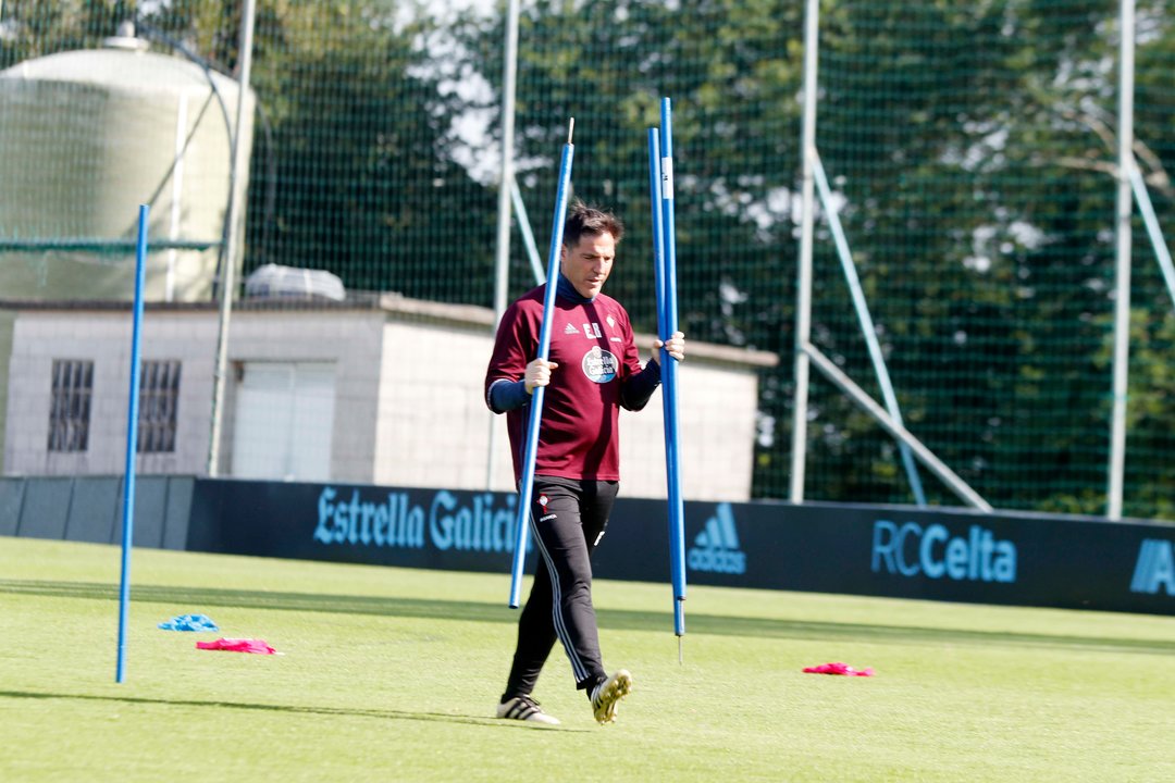 Berizzo porta las picas para marcar el campo durante el entrenamiento de ayer en A Madroa.