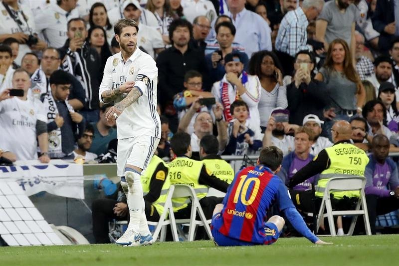 El defensa del Real Madrid, Sergio Ramos (i), tras hacer una falta sobre Lionel Messi (d), por la que fue expulsado