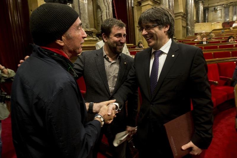 El presidente de la Generalitat de Cataluña, Carles Puigdemont (d), saluda al diputado de JxSí Lluís Llach (i)