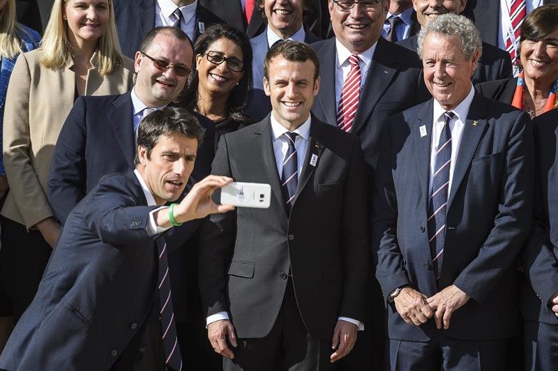 El presidente galo, Emmanuel Macron (c), posa para una foto con el copresidente del Comité Organizador de la candidatura de París 2024, Tony Estanguet (izq)