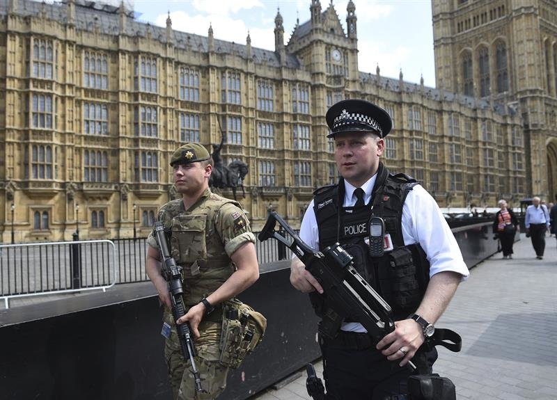 Un soldado y un policía patrullando junto al Parlamento británico.