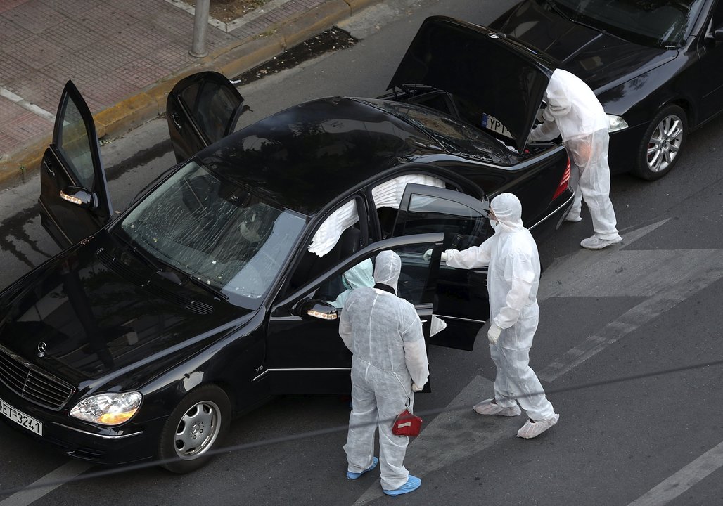 La policía inspecciona el vehículo en el que viajaba el exprimer minsitro griego Papadimos.