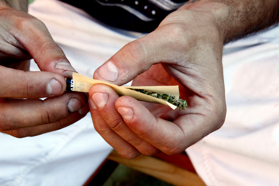 Una persona en el momento de liar un cigarro hecho con cannabis.