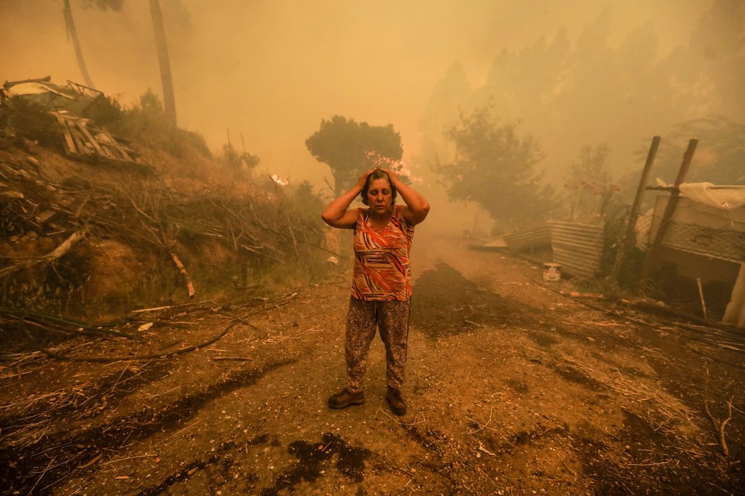 Una mujer se lamenta por lo que el fuego arrasó a su paso en la localidad de Pampilhosa da Serra.