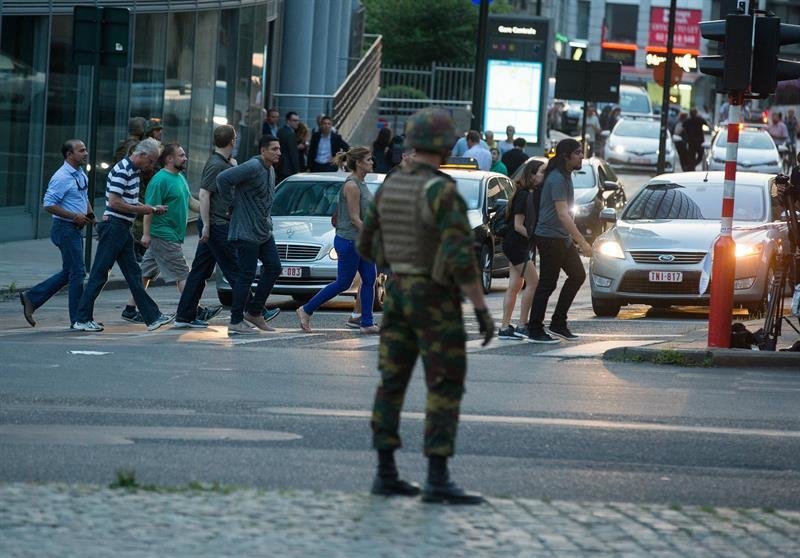 Personas andando junto a un soldado armado en el exterior de la Estación Central de trenes