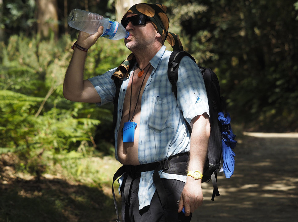 Un peregrino bebe agua en el último tramo del Camino.