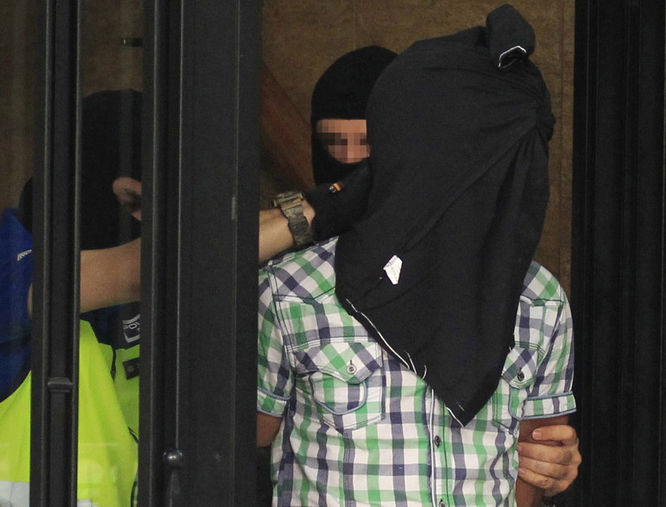 Agentes de la Policía Nacional trasladan a uno de los tres presuntos yihadistas detenidos en Madrid.