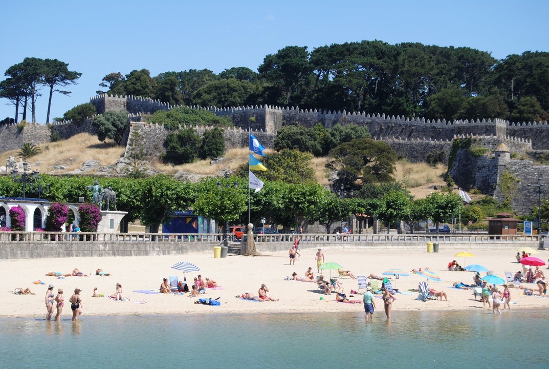 Imagen de la playa de A Ribeira con la bandera de playa sin humo  junto a la insignia Quality Coast y la Bandera Azul.