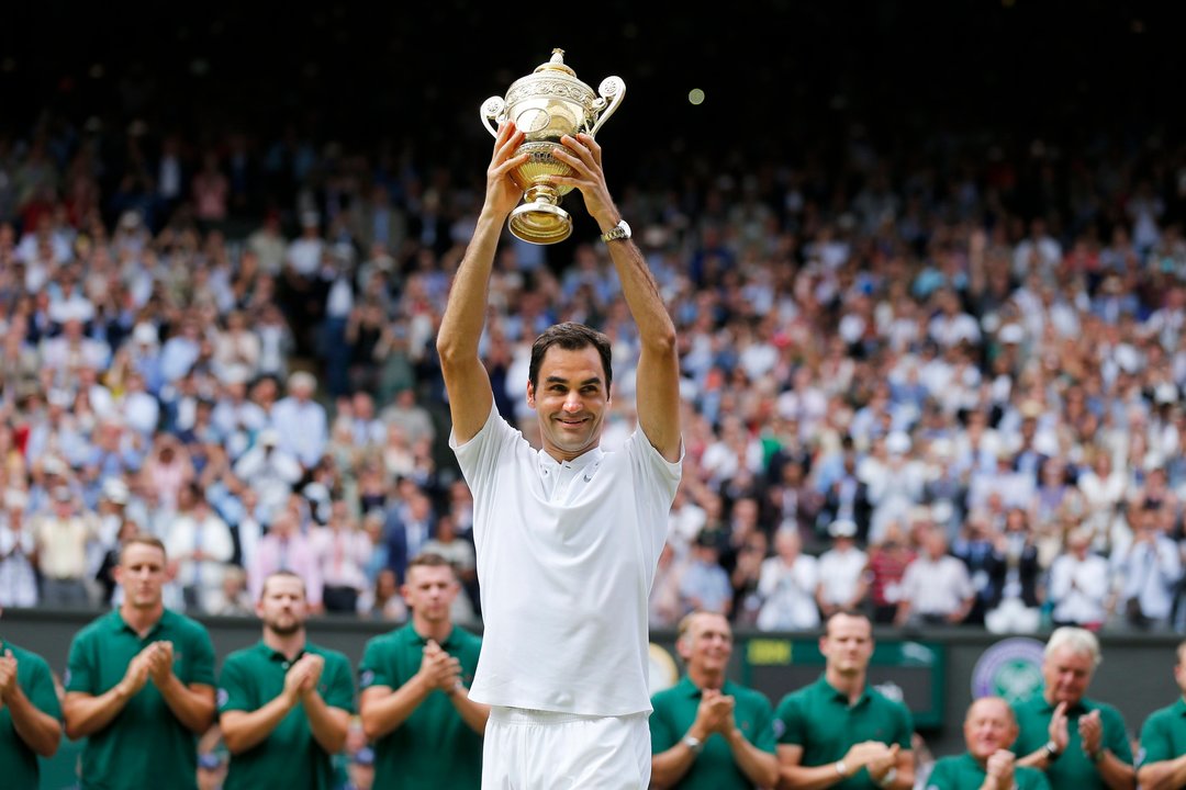 Roger Federer levanta el trofeo que le acredita como ganador de Wimbledon por octava ocasión.