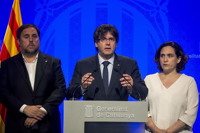 El presidente de la Generalitat, Carles Puigdemont (c), junto a la alcaldesa de Barcelona, Ada Colau (d), y el vicepresidente, Oriol Junqueras (i),