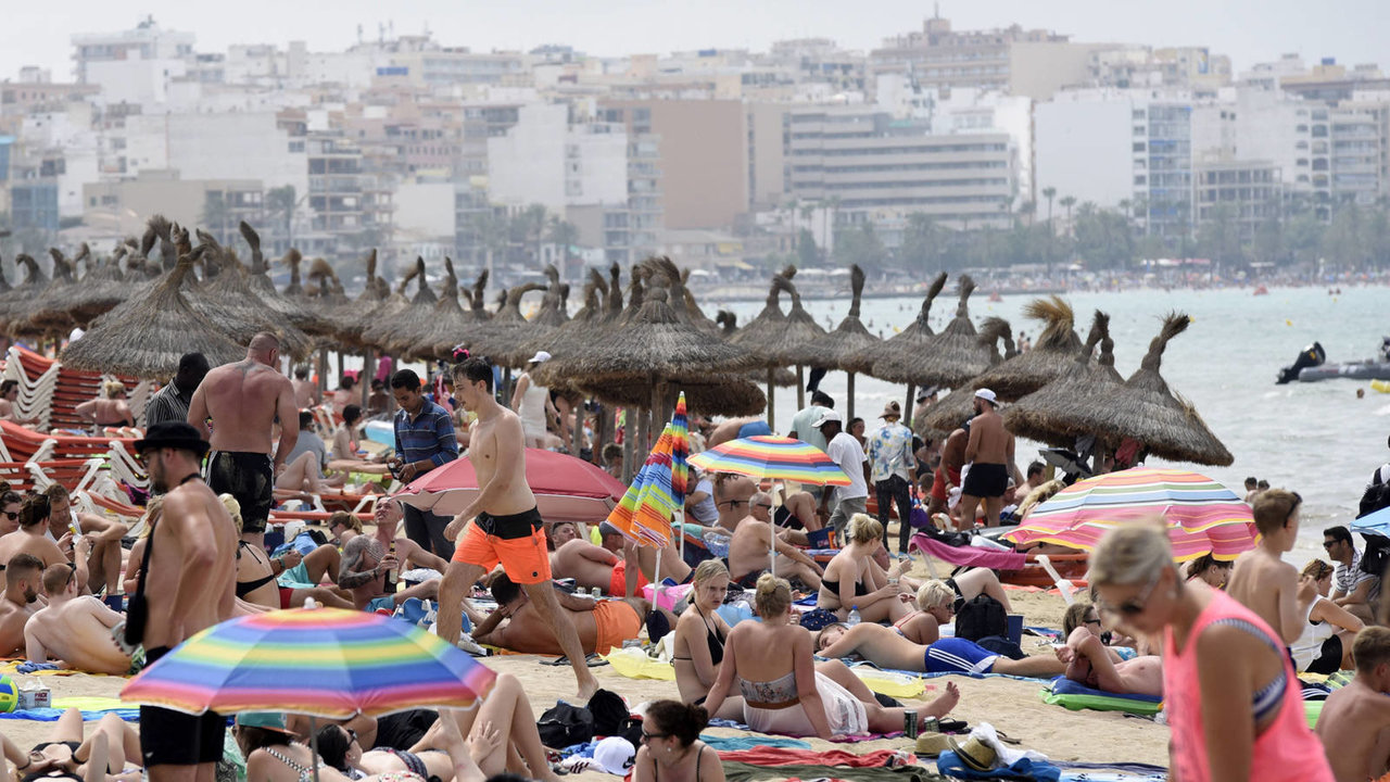Numerosos turistas pasan la jornada en una playa de Palma.
