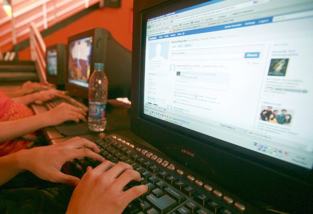 Un trabajador consulta su cuenta de facebook desde el ordenador.