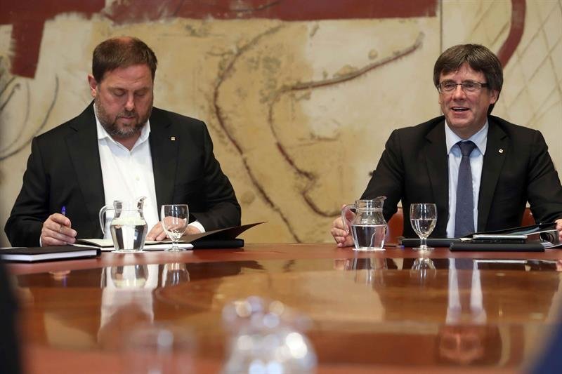 El presidente de la Generalitat, Carles Puigdemont (c), junto al vicepresidente, Oriol Junqueras (i)
