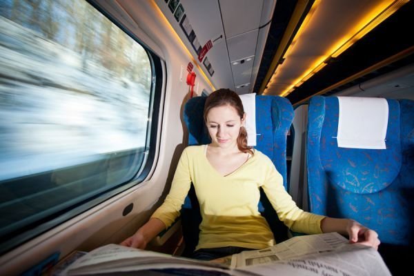 Una joven lee el periódico en un tren de Renfe.