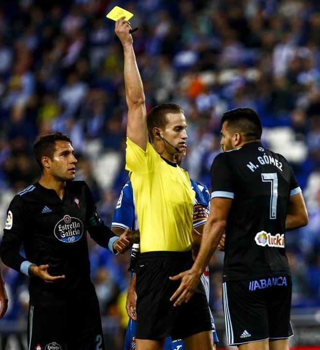 El colegiado Javier Alberola muestra tarjeta amarilla al delantero uruguayo del Celta de Vigo, Maxi Gómez (d)