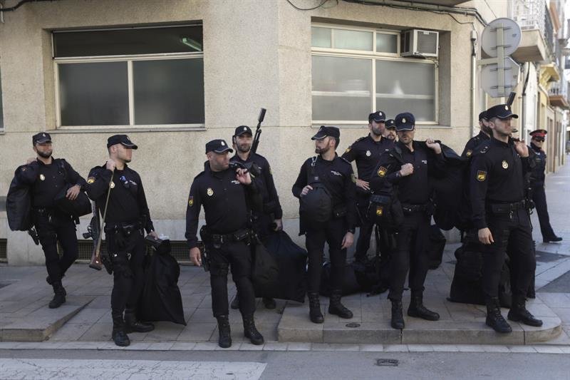Un grupo de policías nacionales espera su transporte delante del hotel Mont-Palau de Pineda (Barcelona)