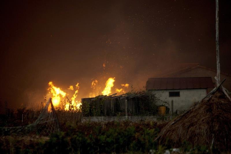 las llamas de uno de los 31 incendios forestales que arrasan Galicia, acercandose a las viviendas situadas en Nigrán