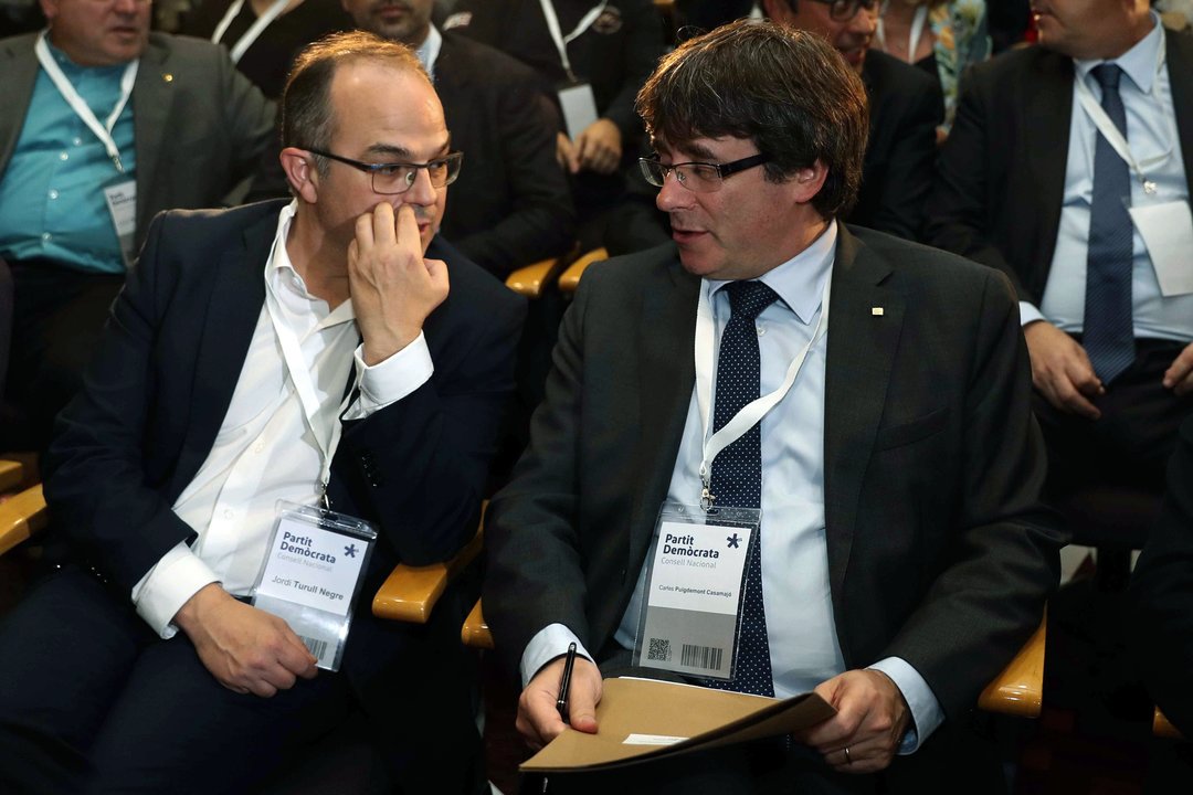 Jordi Turull y Carles Puigdemont conversan en la reunión extraordinaria del consell nacional.