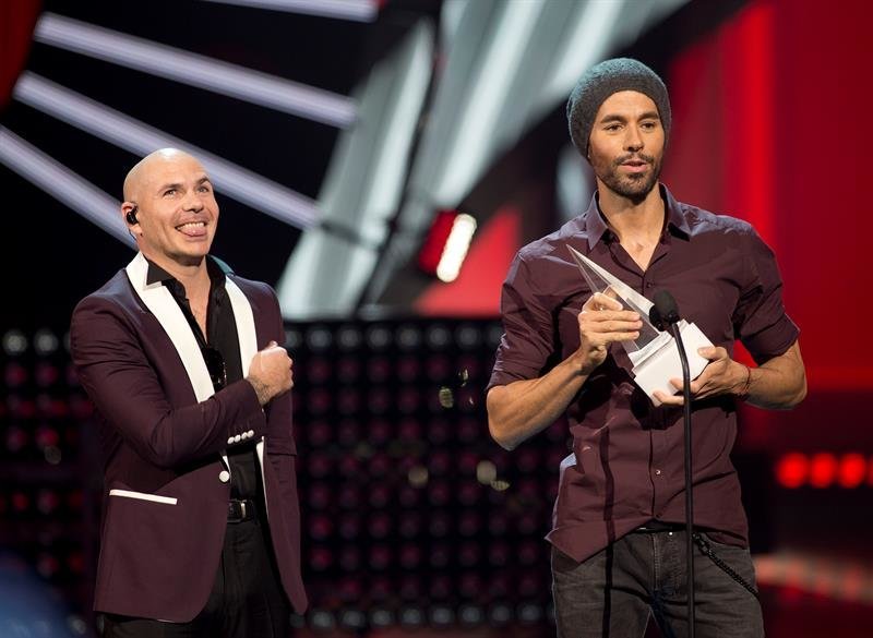 Los artistas Pitbull (i) y Enrique Iglesias, hablan durante los Latin American Music Awards