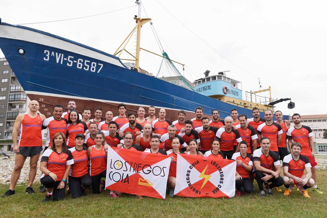 Integrantes del club de atletismo Lóstregos Coia posan delante del barco Bernardo Alfageme.