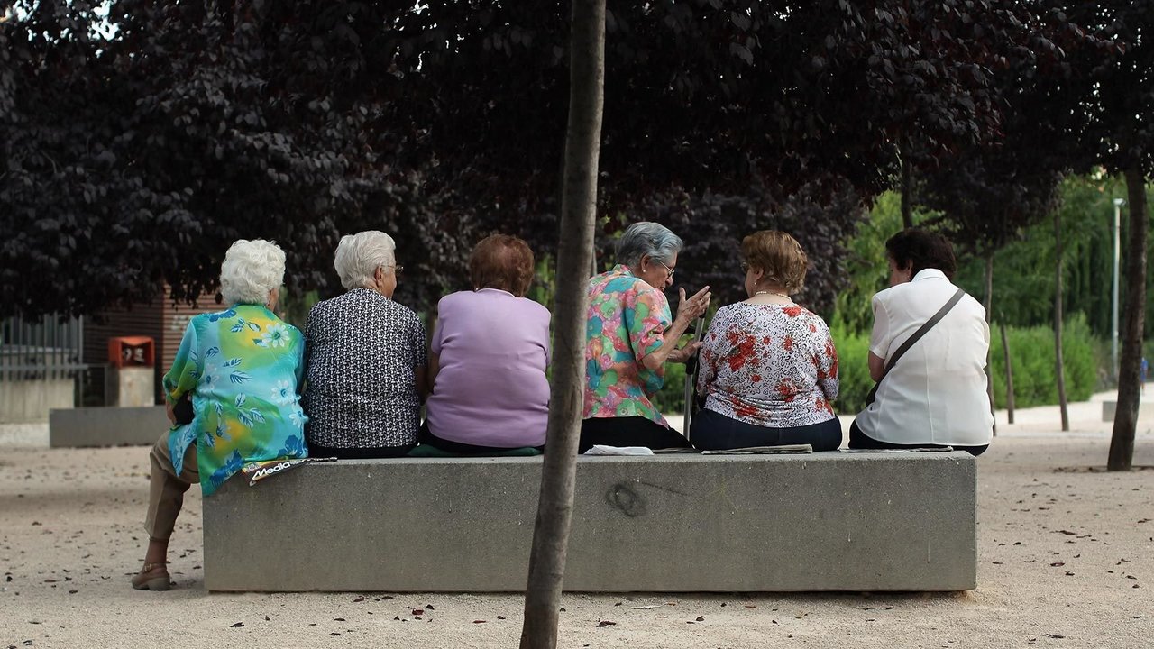 Varias mujeres mayores descansan sentados en un banco.