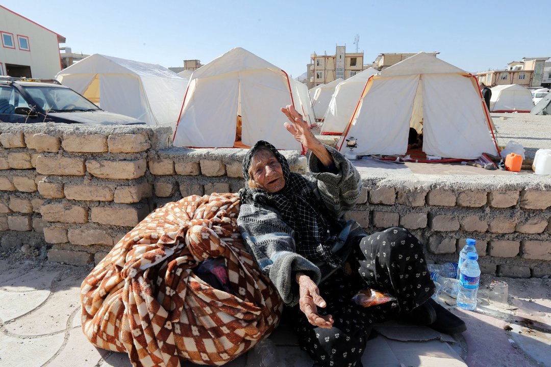 Una mujer, con algunas de sus pertenencias, frente a las tiendas de campaña en Sarpul Zahab.