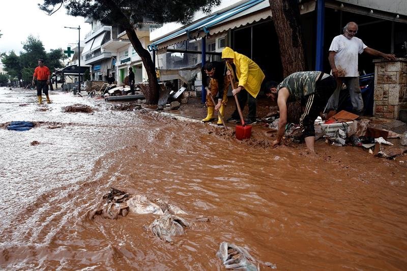 La gente intenta limpiar después de las fuertes lluvias que inundaron Grecia