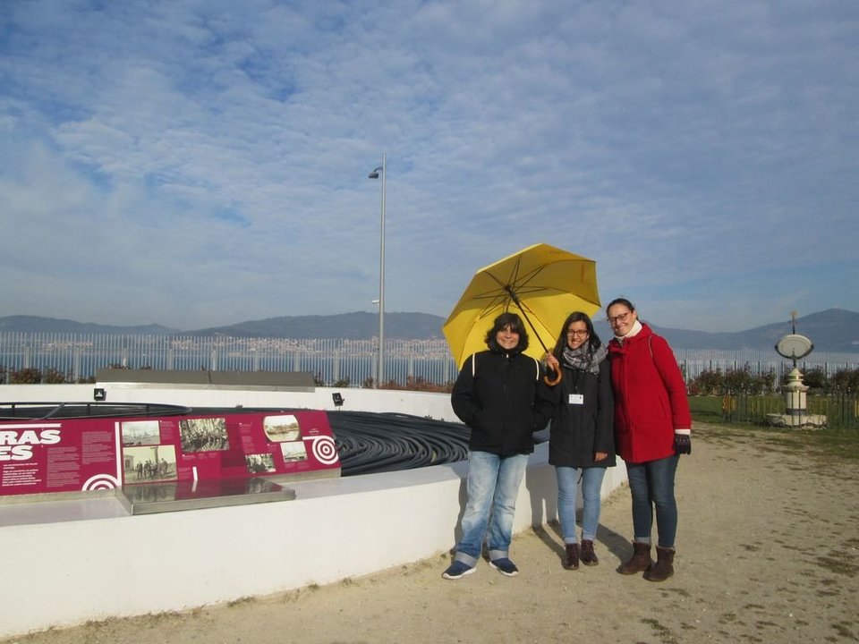 La guía, en el centro, con las &#34;turistas&#34; viguesas Chelo y Rosa en el monumento al cable en el puerto.