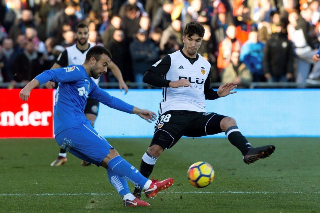 El centrocampista del Valencia Carlos Soler presiona a un rival durante el partido contra el Getafe.