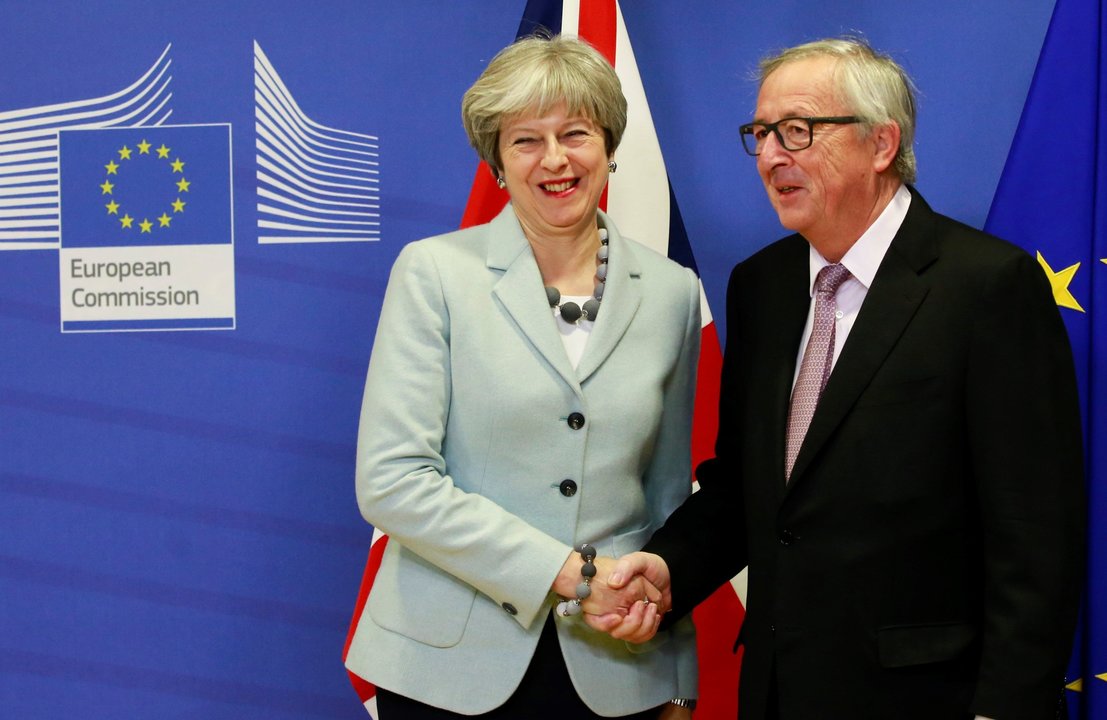 Apretón de manos entre la primera ministra británica Theresa May y el presidente de la CE Juncker.