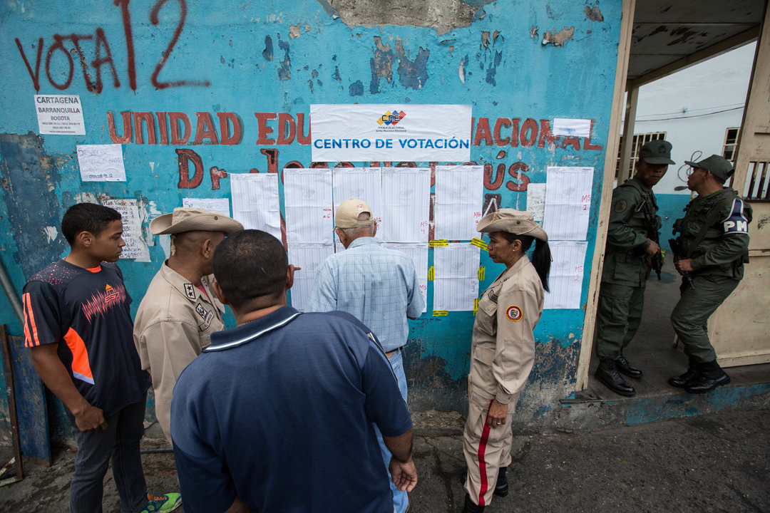 Votantes y militares en el exterior de un colegio electoral de Caracas.