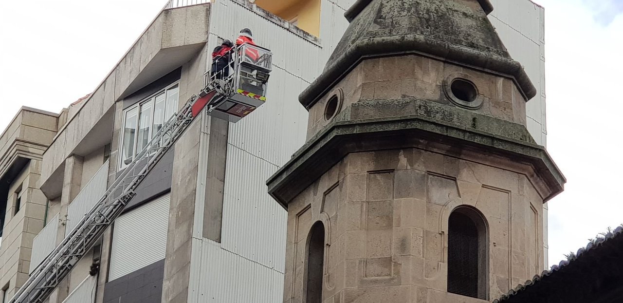 Los bomberos retiran parte de una fachada, que sufrió desprendimientos por culpa del temporal, en Ecuador.