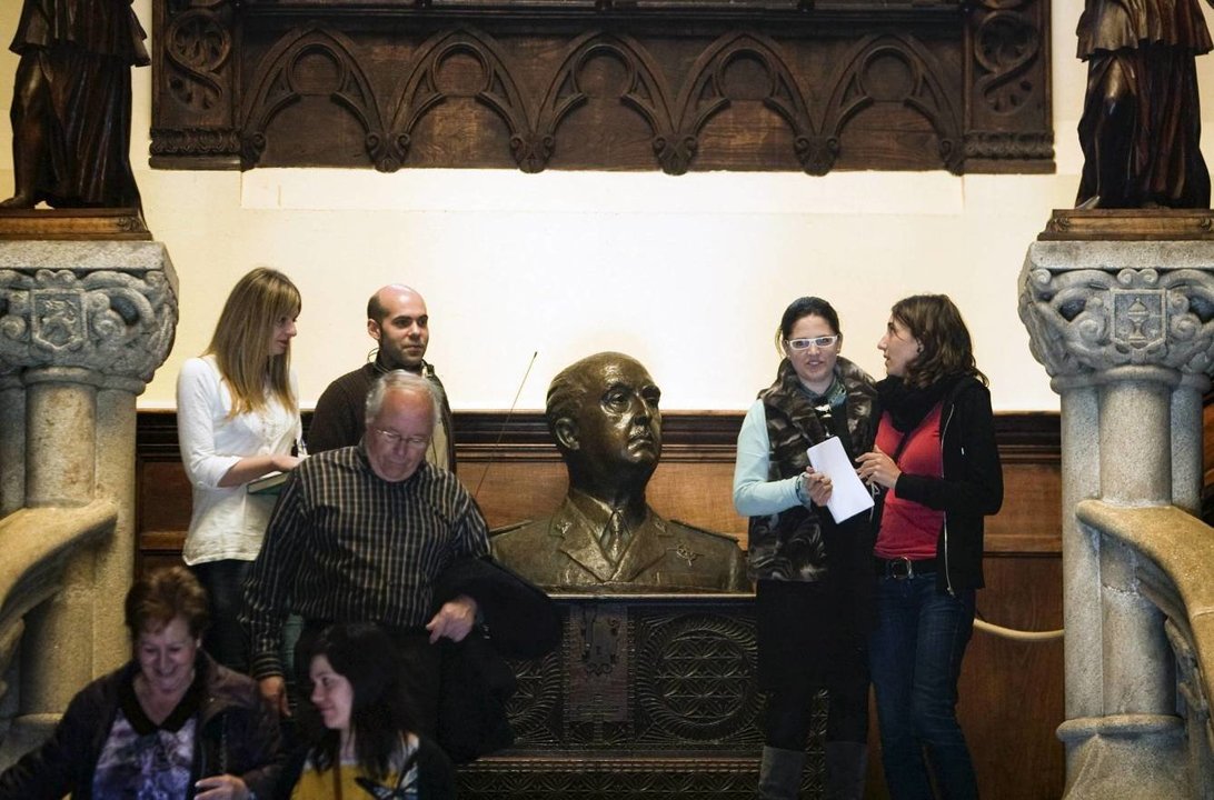 Un grupo de visitantes, en el interior del pazo al lado de un busto del general Franco.