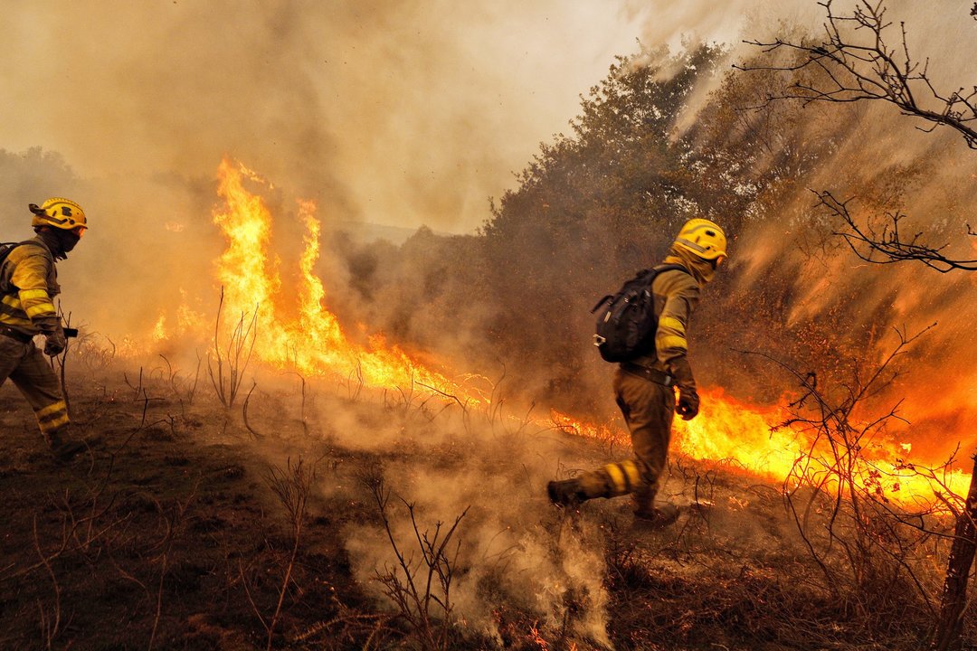 Dos agentes de extincion trabajan contra el fuego en los incendios del mes de octubre.