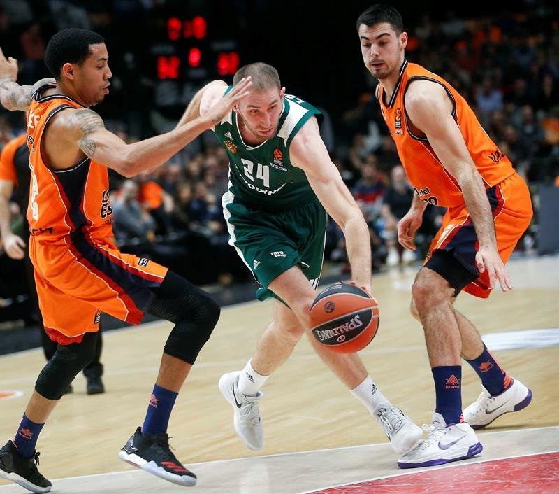 El jugador del Panathinaikos , Matt Lojeski, trata de vencer la oposición de los del Valencia Basket, Erick Green (i) y Alberto Abalde