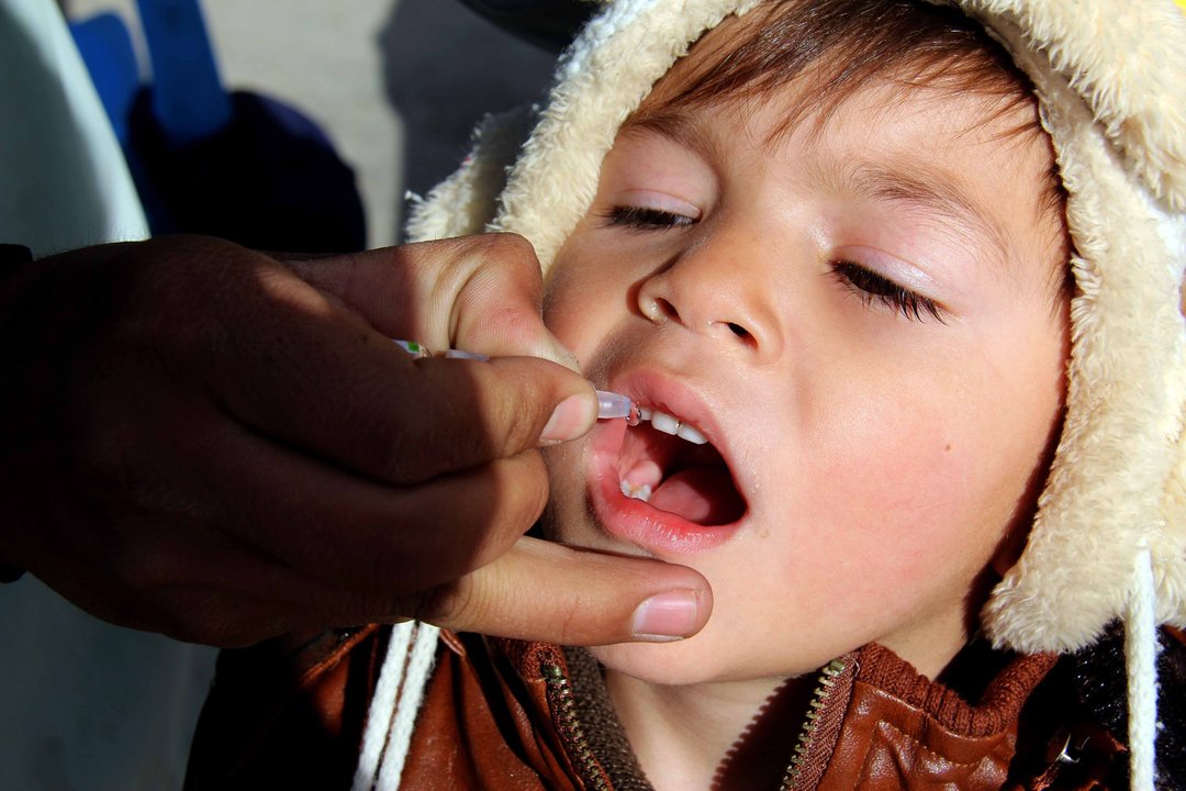 Administración de la vacuna contra la poliomelites a un niño en Afganistán.