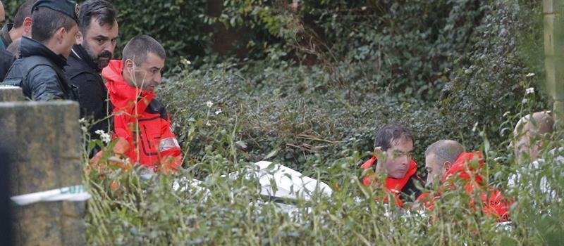Efectivos de la Guardia Civil y bomberos trasladan en una camilla los restos del cadáver de Diana Quer