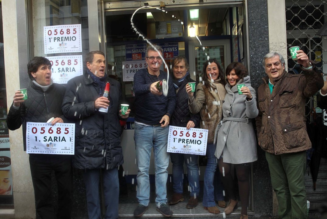 Los dueños y trabajadores de la Administración de Lotería de la Avenida Lehendakari Aguirre en Bilbao celebran la venta del primer premio.