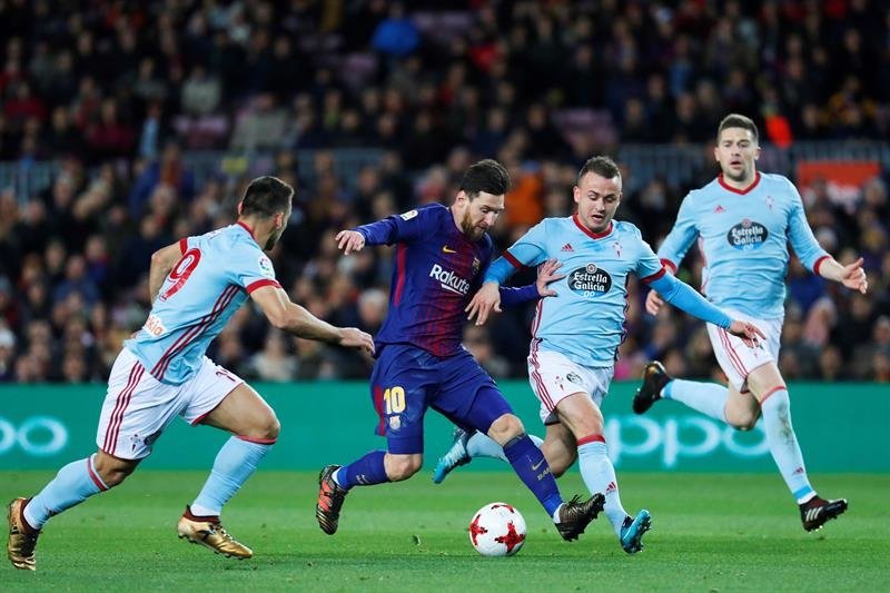 El delantero argentino del FC Barcelona Lionel Messi (c) con el balón ante los jugadores del Celta de Vigo