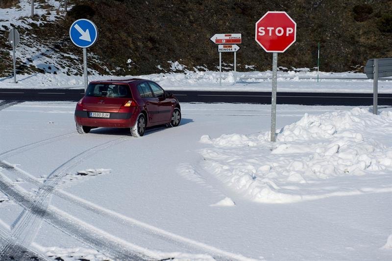 Un coche circula en una carretera con nieve