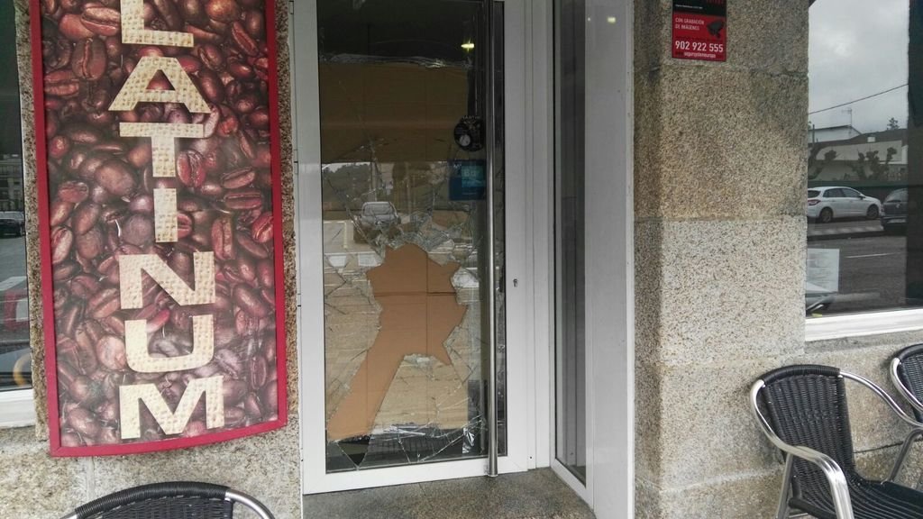 La puerta de entrada de la cafetería con el cristal roto a pedradas. Es el tercer robo, según la dueña.