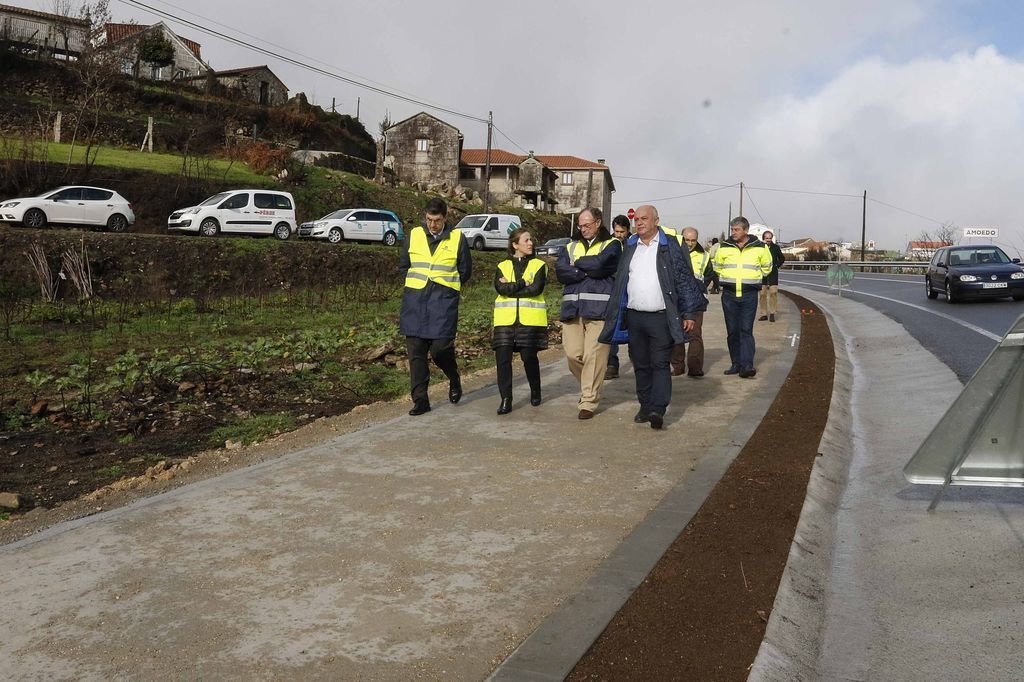 La conselleira acompañada del alcalde de pazos de Bobén recorren la nueva senda peatonal.