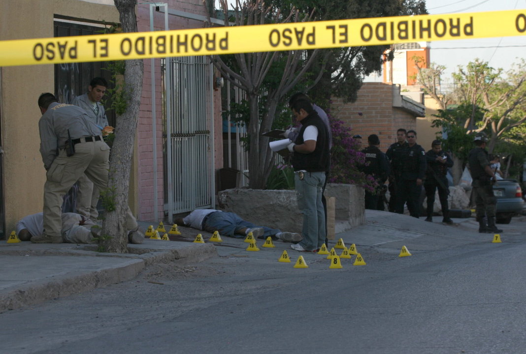 Policías mexicanos en el lugar del asesinato de dos personas en Ciudad Juárez, en la frontera con EEUU.
